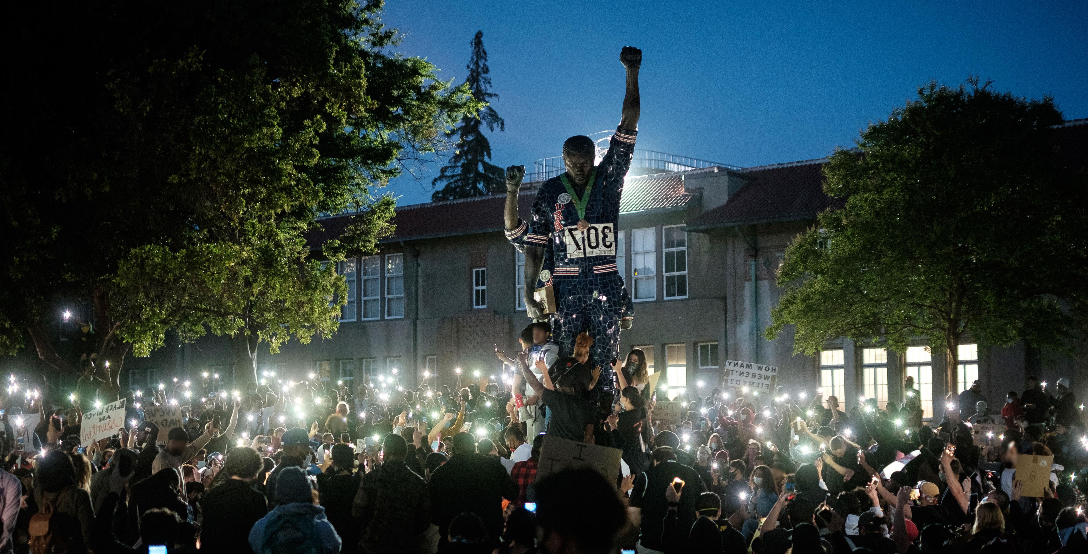 Students gathering around Smith and Carlos statue.